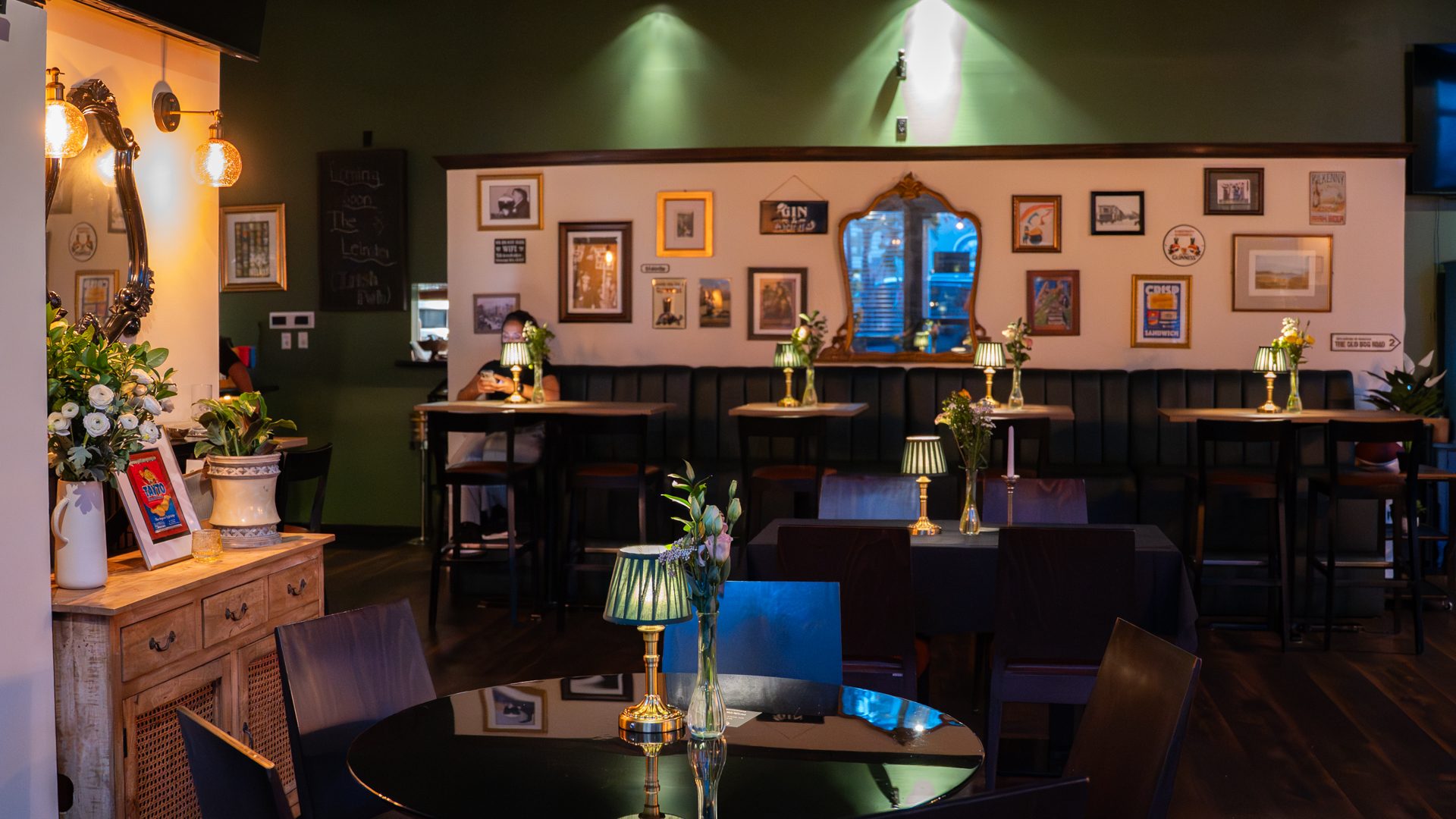 The Leinster dining room with green walls, framed artwork, and candlelit tables