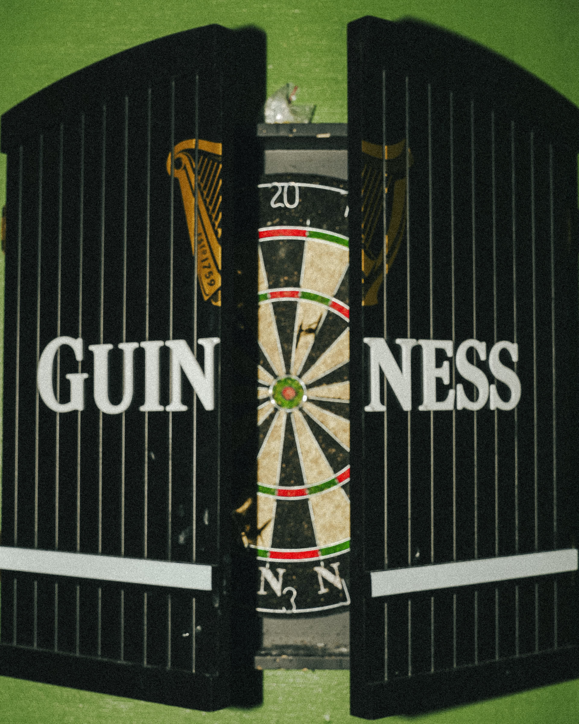 Guinness branded dartboard on green wall at The Leinster Irish Pub Miami